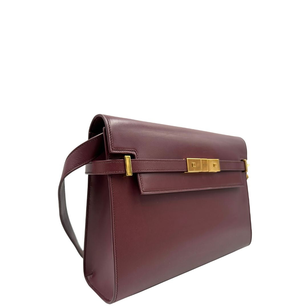 Borsa Saint Laurent Manhattan in pelle bordeaux e hardware dorato, da portare a spalla.