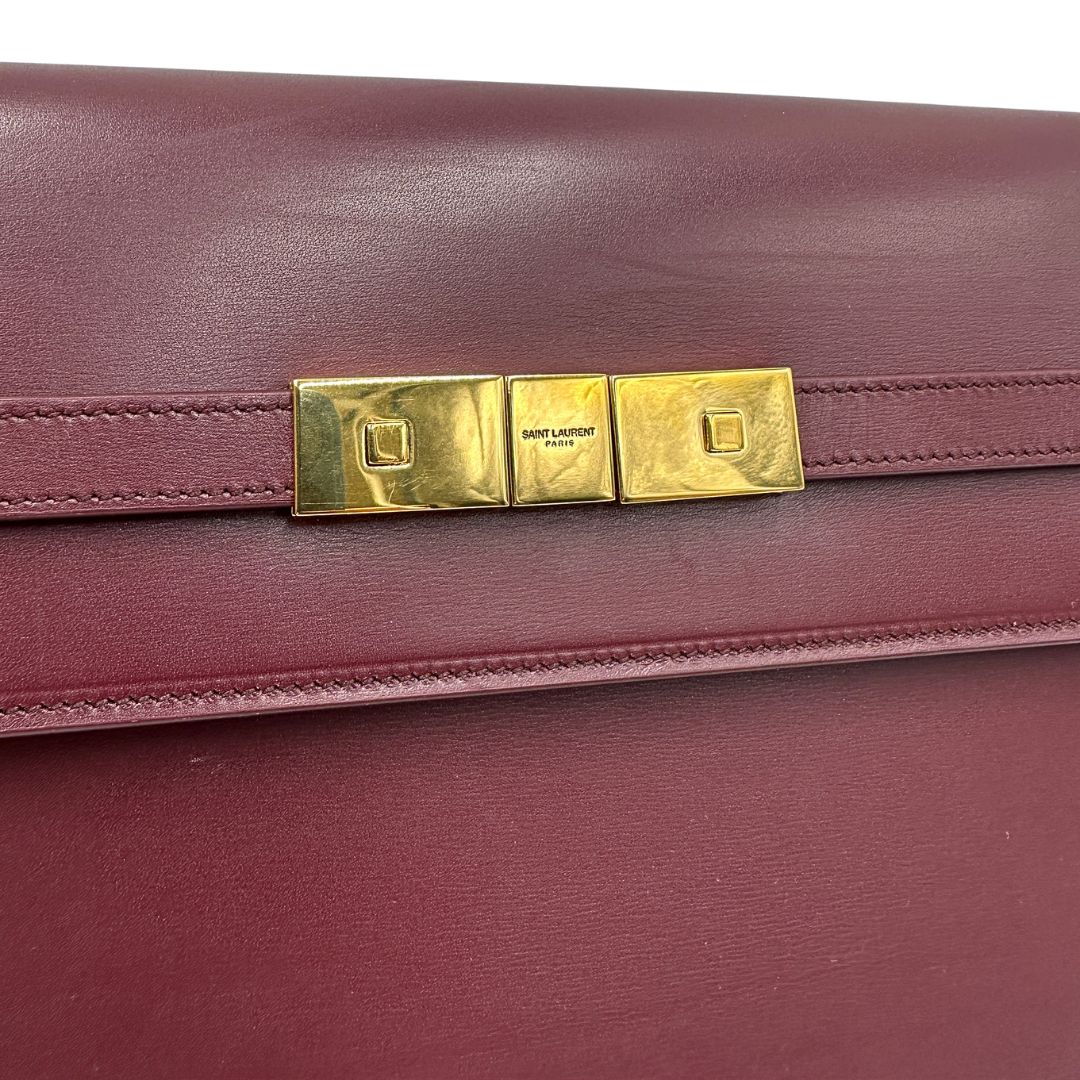 Borsa Saint Laurent Manhattan in pelle bordeaux e hardware dorato, da portare a spalla.