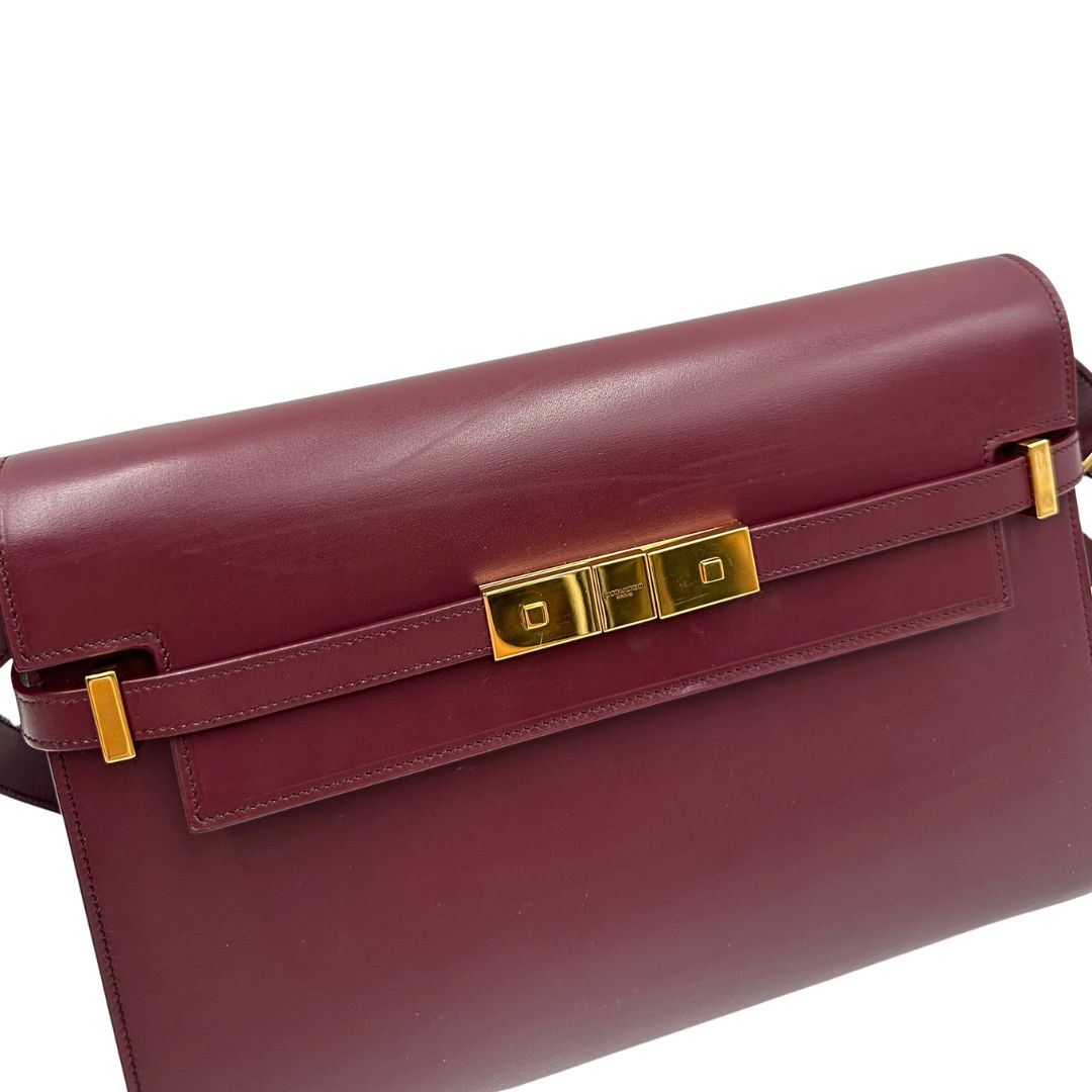 Borsa Saint Laurent Manhattan in pelle bordeaux e hardware dorato, da portare a spalla.