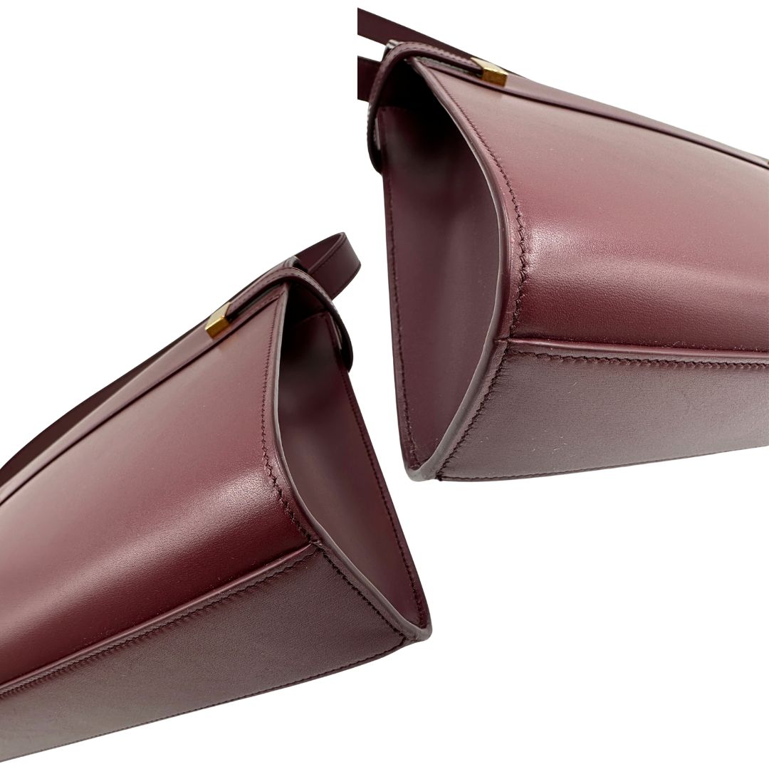 Borsa Saint Laurent Manhattan in pelle bordeaux e hardware dorato, da portare a spalla.