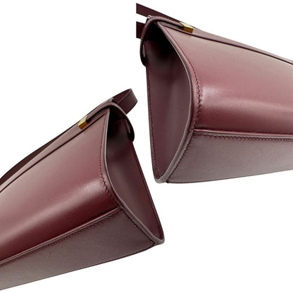 Borsa Saint Laurent Manhattan in pelle bordeaux e hardware dorato, da portare a spalla.