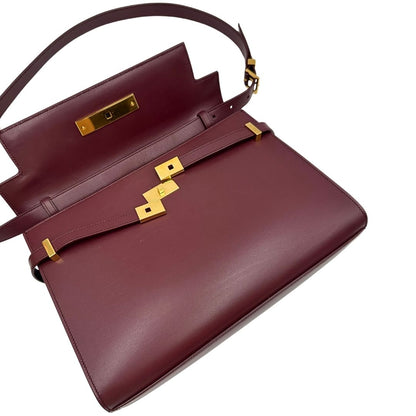 Borsa Saint Laurent Manhattan in pelle bordeaux e hardware dorato, da portare a spalla.