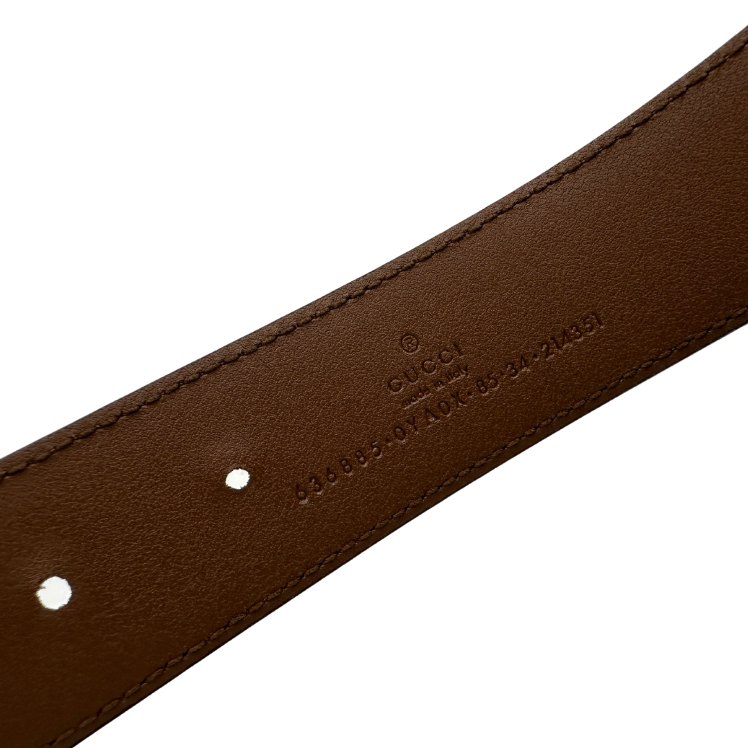 Cintura Gucci in pelle marrone con fibbia tradizionale in metallo argentato e grande elemento decorativo GG dorato inserito lungo la cintura. Originale, usata, di lusso, in ottime condizioni.