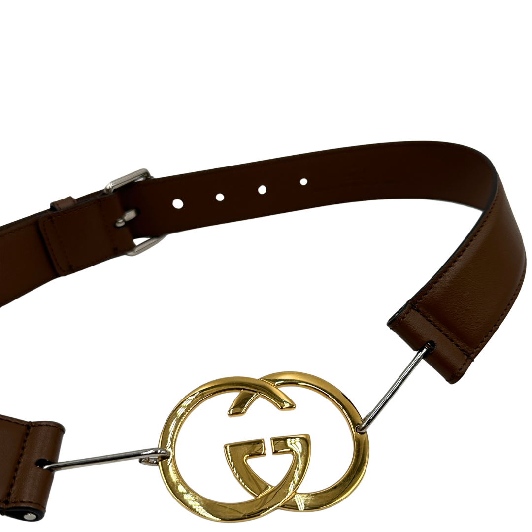 Cintura Gucci in pelle marrone con fibbia tradizionale in metallo argentato e grande elemento decorativo GG dorato inserito lungo la cintura. Originale, usata, di lusso, in ottime condizioni.