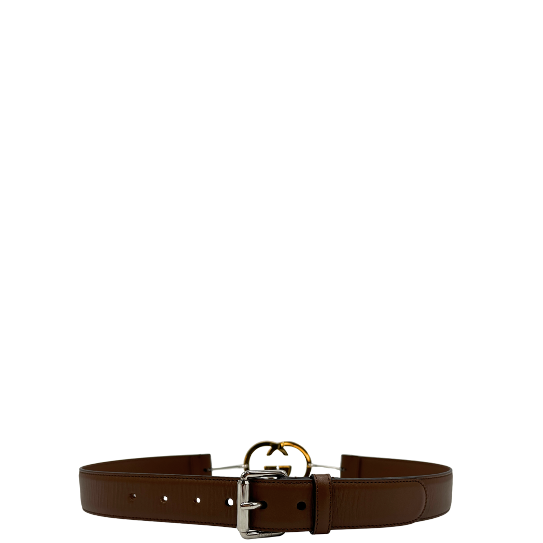Cintura Gucci in pelle marrone con fibbia tradizionale in metallo argentato e grande elemento decorativo GG dorato inserito lungo la cintura. Originale, usata, di lusso, in ottime condizioni.