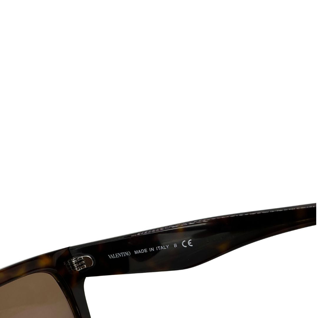 Occhiali da sole realizzati in acetato tartarugato scuro con lenti marroni, Le aste larghe sono impreziosite dall’iconico logo Valentino VLogo in contrasto. Originale, usati, di lusso, in ottime condizioni.