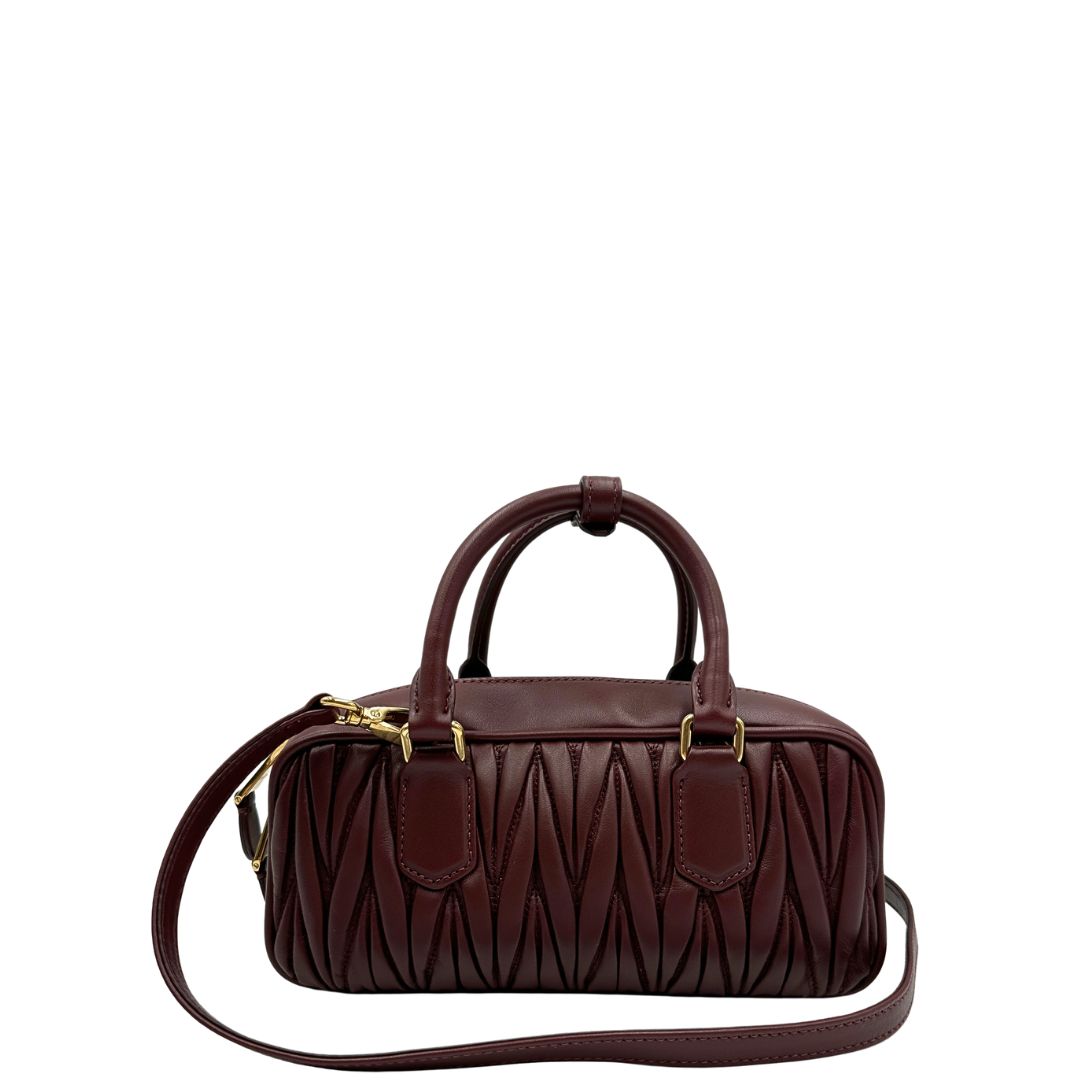 Retro, Borsa Miu Miu Arcadie realizzata in nappa matelassé bordeaux con la classica silhouette del bauletto. Da portare a mano o a tracolla. Originale, usata, di lusso, in condizioni eccellenti.