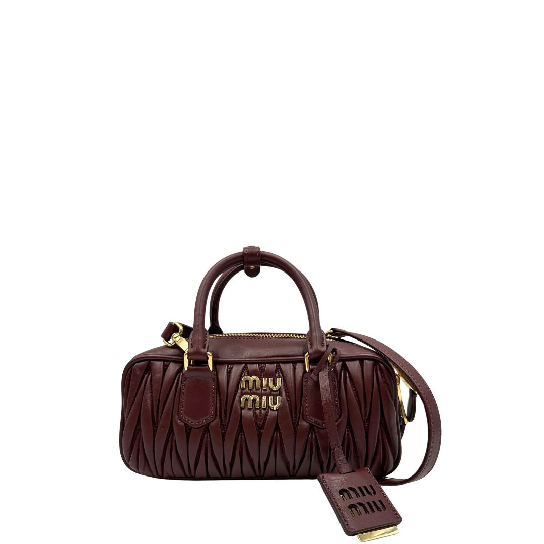 Front, Borsa Miu Miu Arcadie realizzata in nappa matelassé bordeaux con la classica silhouette del bauletto. Da portare a mano o a tracolla. Originale, usata, di lusso, in condizioni eccellenti.