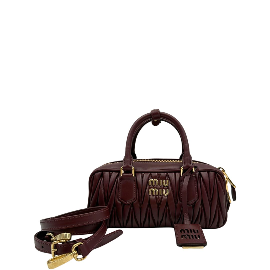 Front, Borsa Miu Miu Arcadie realizzata in nappa matelassé bordeaux con la classica silhouette del bauletto. Da portare a mano o a tracolla. Originale, usata, di lusso, in condizioni eccellenti.