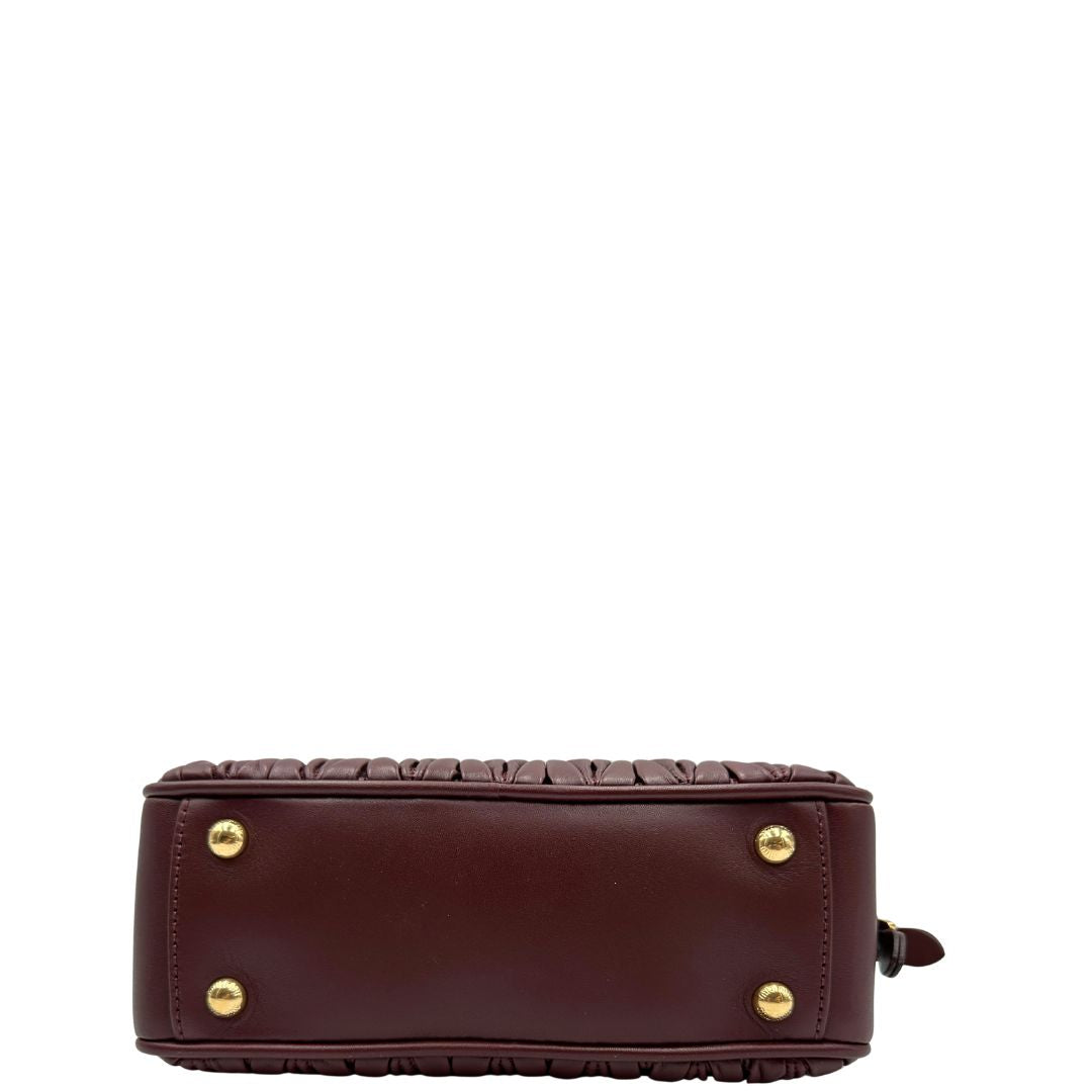 Base, Borsa Miu Miu Arcadie realizzata in nappa matelassé bordeaux con la classica silhouette del bauletto. Da portare a mano o a tracolla. Originale, usata, di lusso, in condizioni eccellenti.