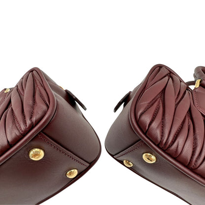 Angoli, Borsa Miu Miu Arcadie realizzata in nappa matelassé bordeaux con la classica silhouette del bauletto. Da portare a mano o a tracolla. Originale, usata, di lusso, in condizioni eccellenti.