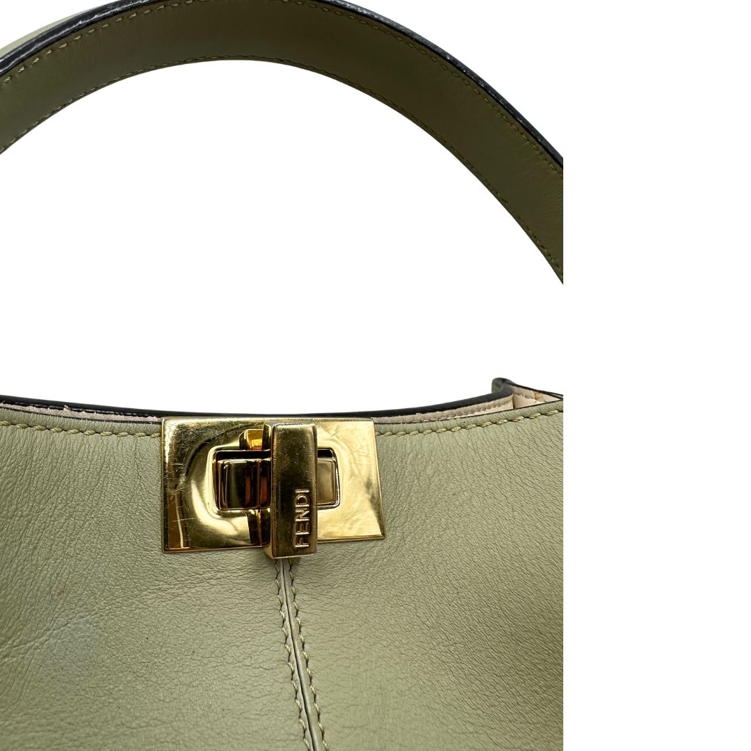 Chiusura, Elegante borsa Fendi Peekaboo in morbida pelle color verde salvia caratterizzata dall’iconica chiusura girevole in metallo dorato, dotata di manico superiore e ampia tracolla removibile in tessuto. da indossare a mano oppure a spalla. Originale, usata, di lusso, in ottime condizioni.