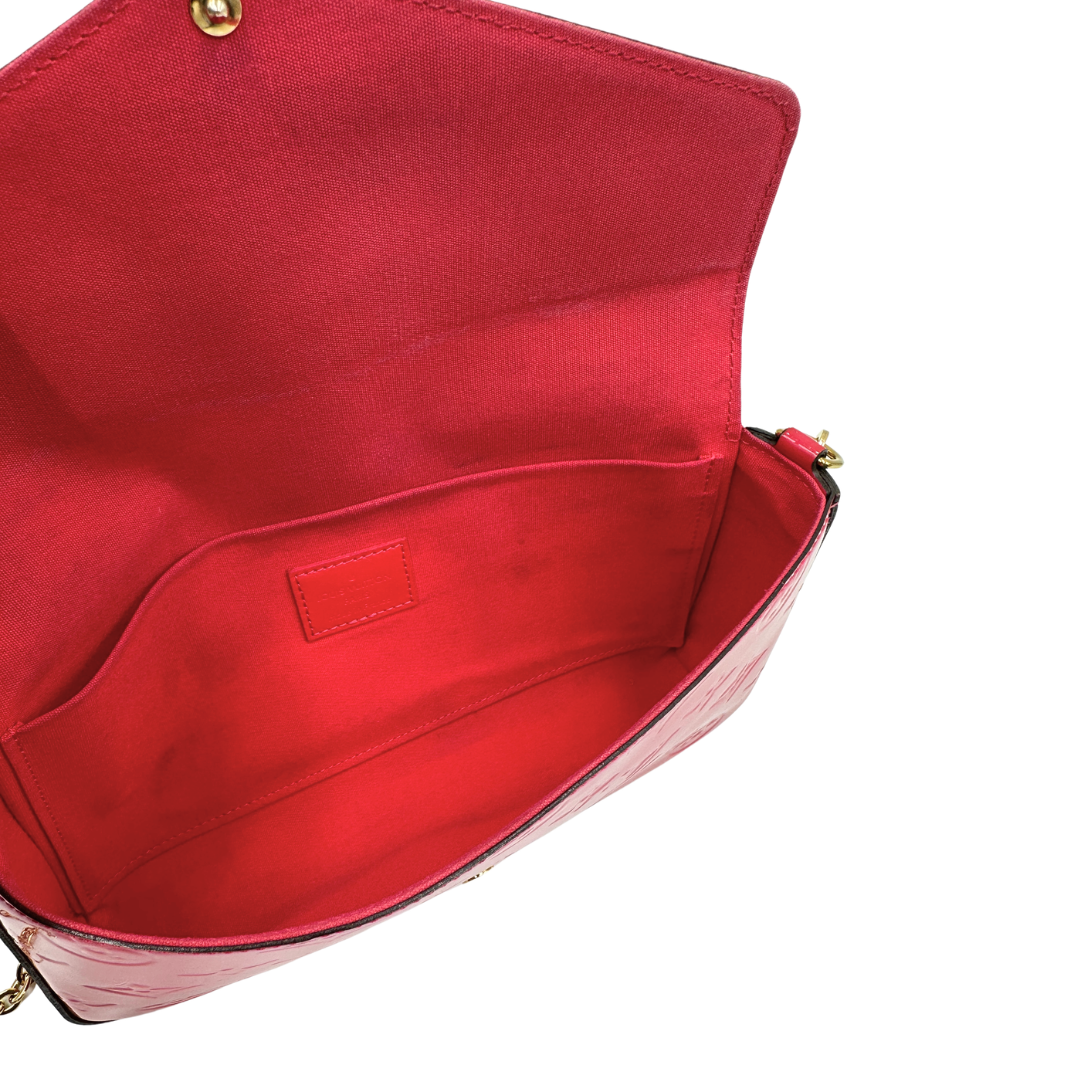 Interno, Pratica tracolla Louis Vuitton in pelle verniciata fucsia monogram con parti metalliche dorate. Munita di una tracolla in catena amovibile, ma non regolabile e di accessori estraibili portamonete e portacarte. Originale, usata, di lusso, in ottime condizioni.