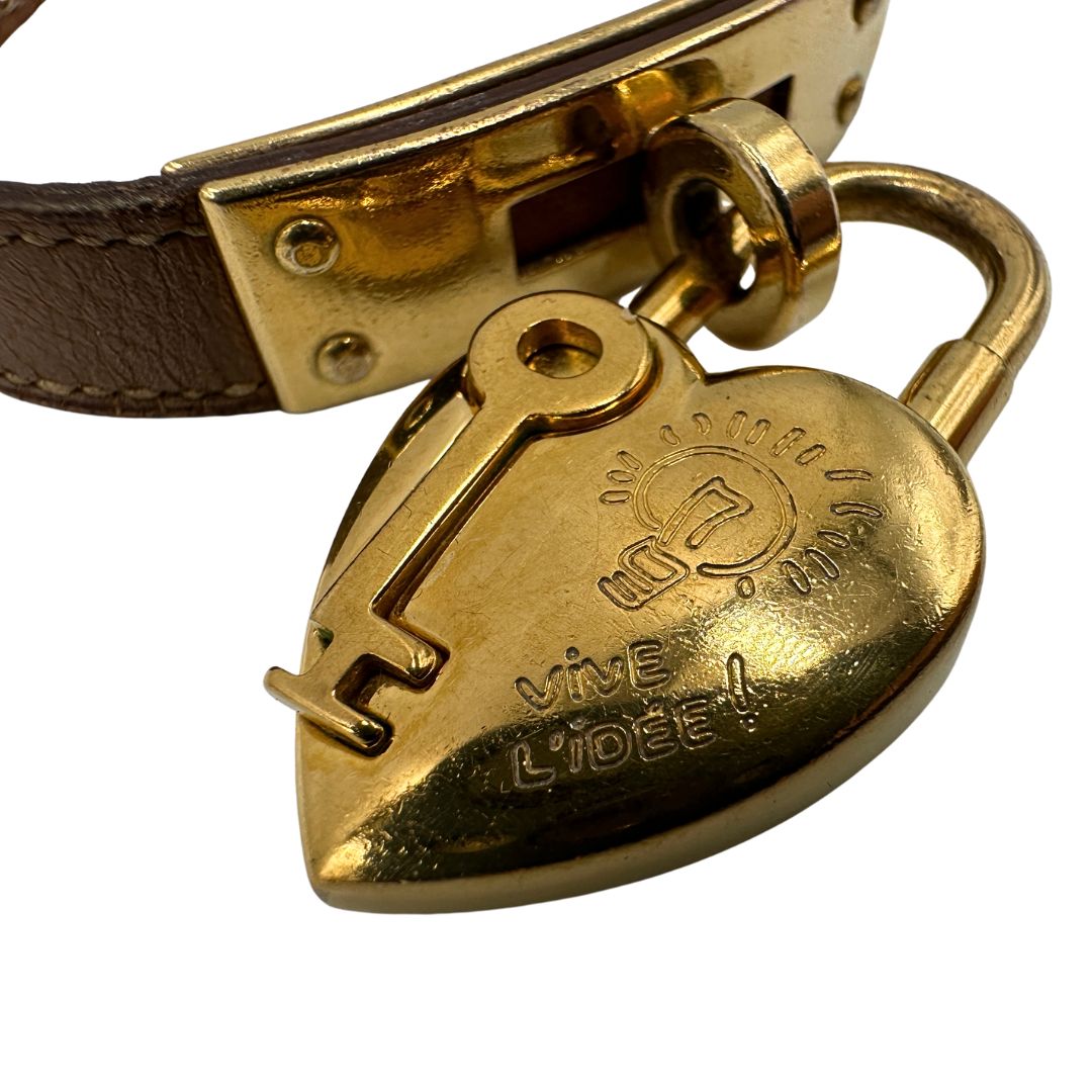 Elegante Hermès Année de la Fantaisie "Vive l'Idée!", bracciale in pelle marrone con finiture dorate e un caratteristico lucchetto a forma di cuore.