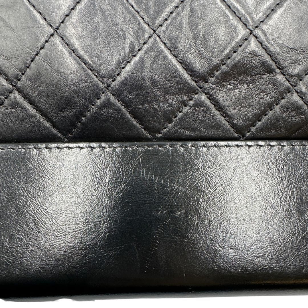 Chanel Gabrielle Hobo Bag in pelle di vitello trapuntata nera, caratterizzata da una solida base rigida inferiore, dettagli con finiture miste color oro e argento e una tracolla regolabile a catena intrecciata in pelle 