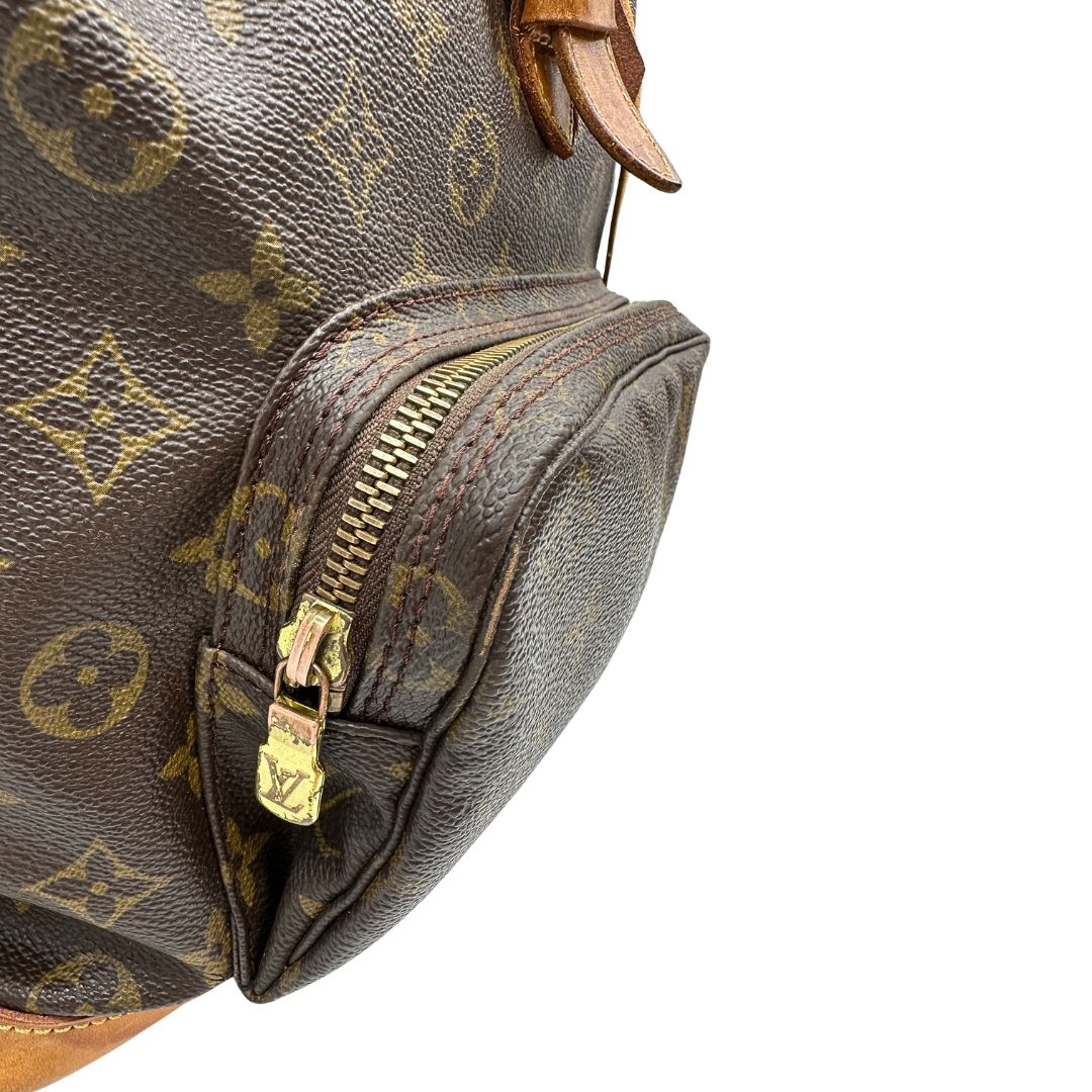 Segni di utilizzo sulle parti metalliche di uno zaino Montsouris GM in canvas marrone monogram con finiture in vacchetta naturale.