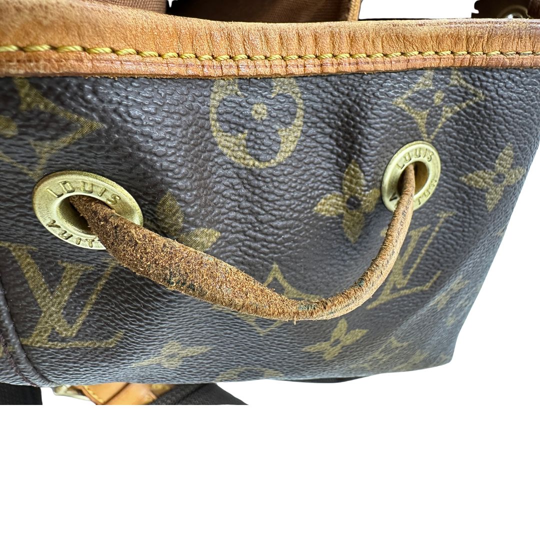 Segni di utilizzo sulla vacchetta di uno zaino Montsouris GM in canvas marrone monogram con finiture in vacchetta naturale.