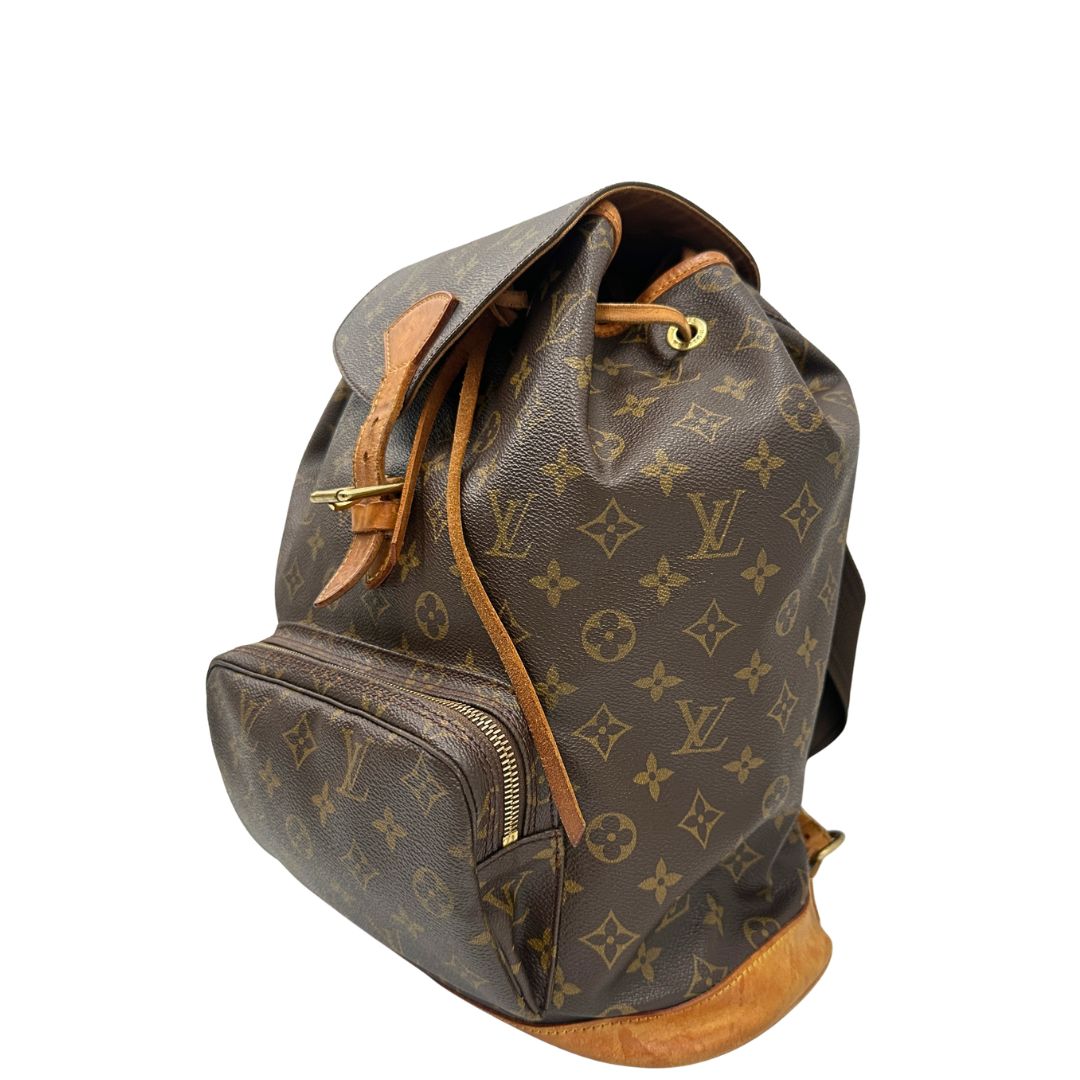Laterale di uno zaino Montsouris GM in canvas marrone monogram con finiture in vacchetta naturale.
