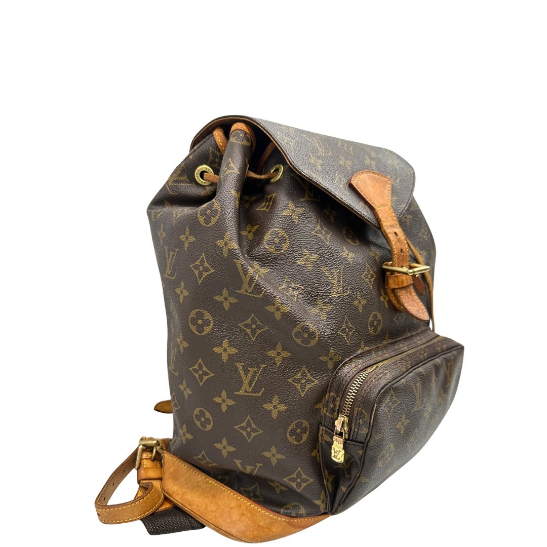 Laterale di uno zaino Montsouris GM in canvas marrone monogram con finiture in vacchetta naturale.