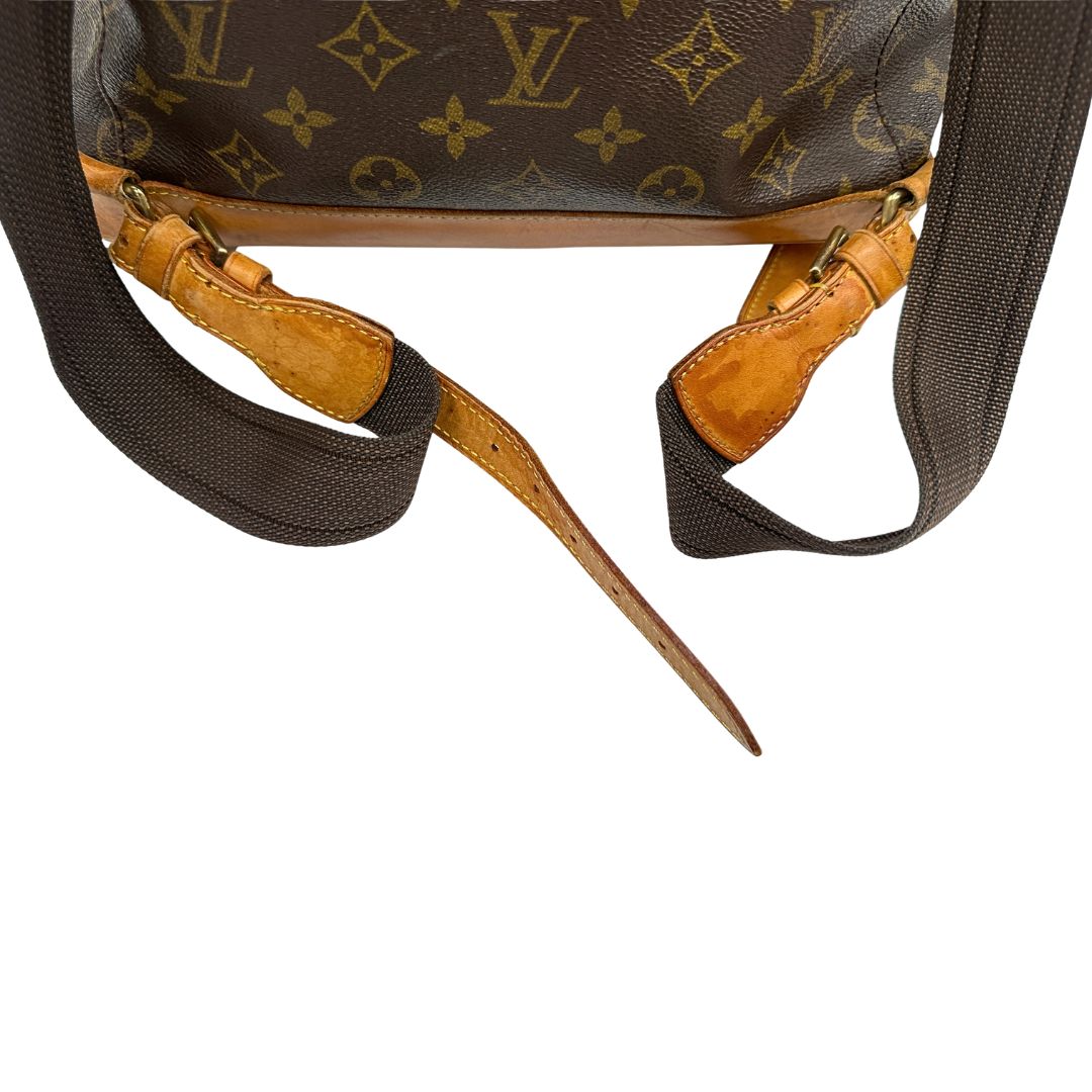 Segni di utilizzo sulla vacchetta di uno zaino Montsouris GM in canvas marrone monogram con finiture in vacchetta naturale.