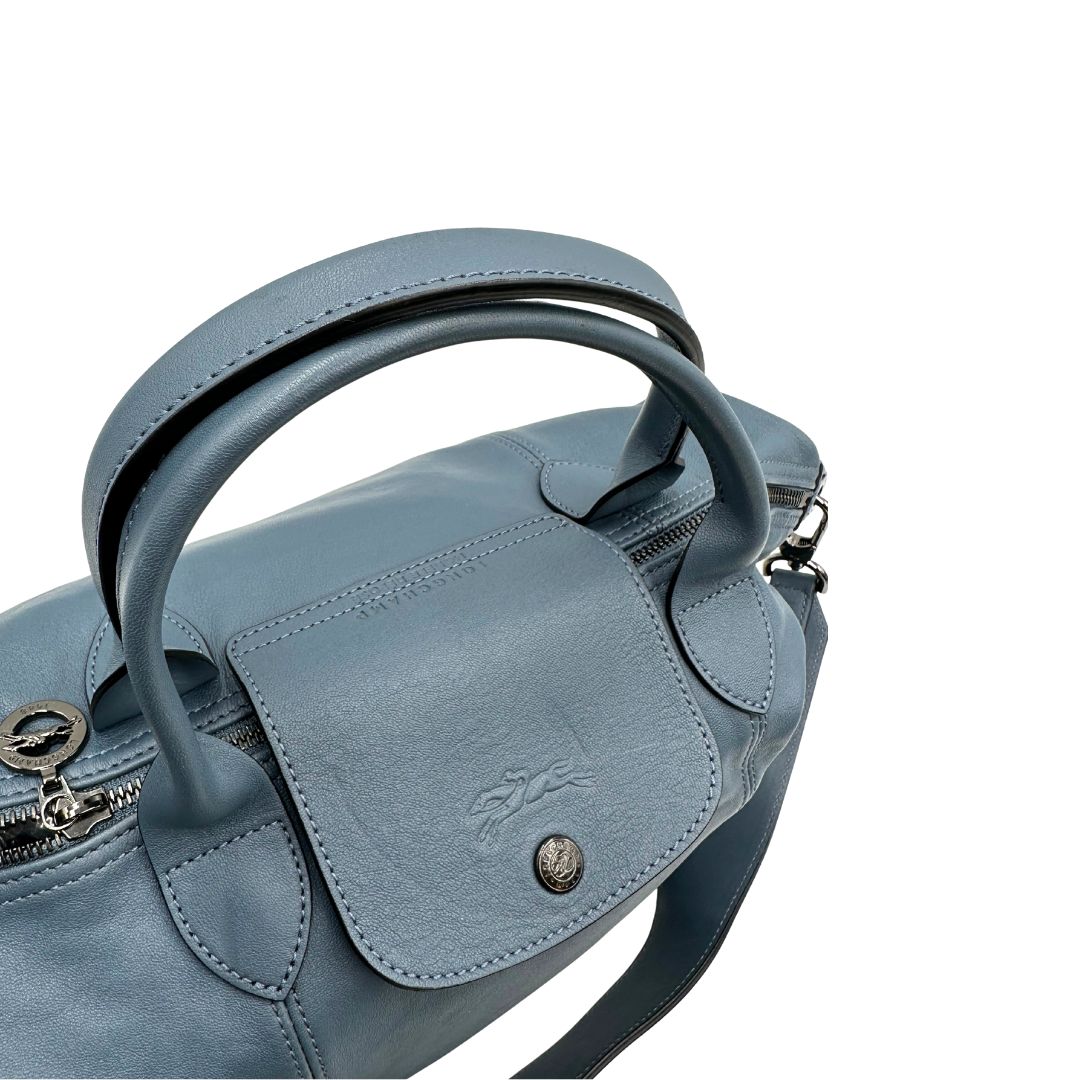 Manici Borsa Longchamp Le Pliage in pelle Blu avio dotata di doppi manici stondati e di una tracolla regolabile, amovibile. Rifinita con parti metalliche argentate.