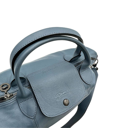 Manici Borsa Longchamp Le Pliage in pelle Blu avio dotata di doppi manici stondati e di una tracolla regolabile, amovibile. Rifinita con parti metalliche argentate.