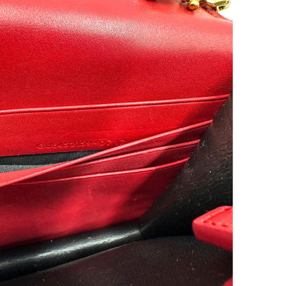 Borsa Kate Wallet on Chain Saint Laurent in pelle rossa con parti metalliche dorate e nappa decorativa a catena, indossabile a tracolla.