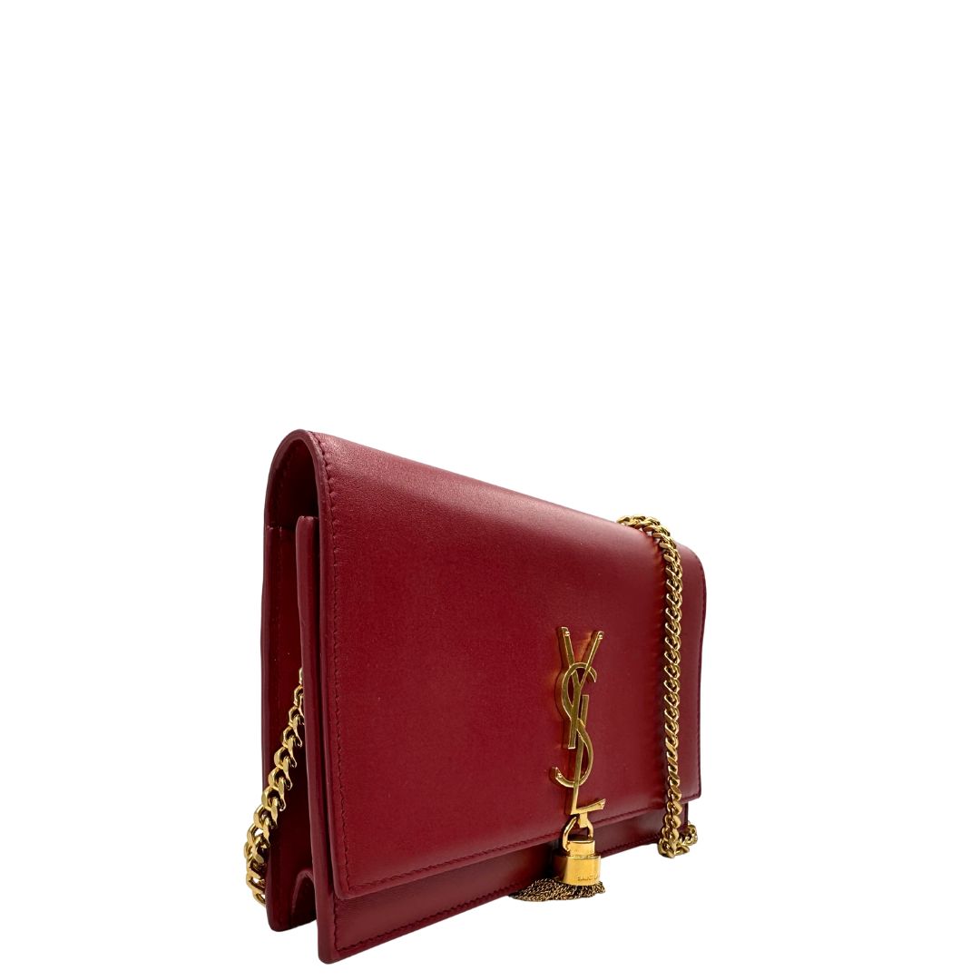 Laterale Borsa Kate Wallet on Chain Saint Laurent in pelle rossa con parti metalliche dorate e nappa decorativa a catena, indossabile a tracolla.