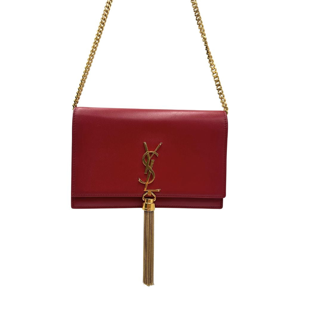 Front Borsa Kate Wallet on Chain Saint Laurent in pelle rossa con parti metalliche dorate e nappa decorativa a catena, indossabile a tracolla.