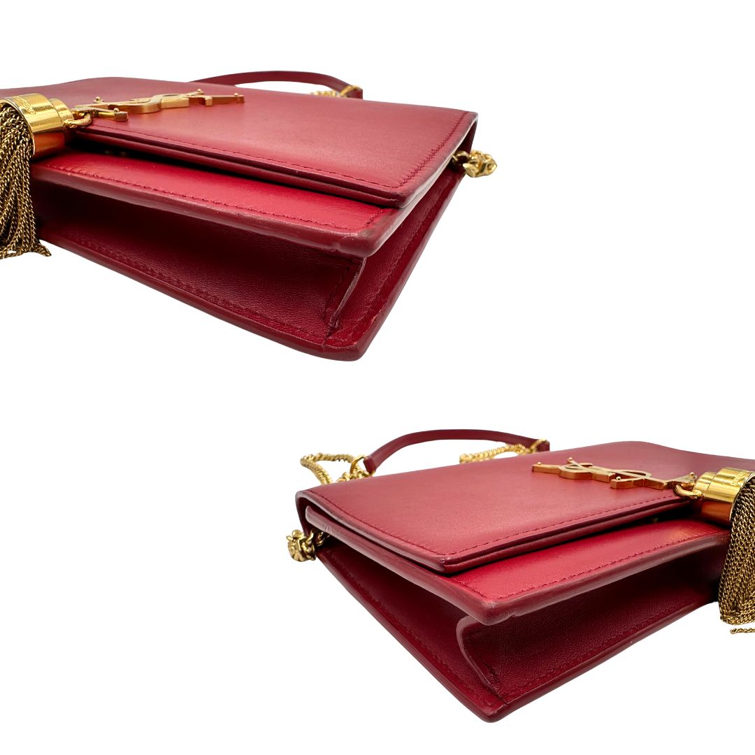 Angoli Borsa Kate Wallet on Chain Saint Laurent in pelle rossa con parti metalliche dorate e nappa decorativa a catena, indossabile a tracolla.