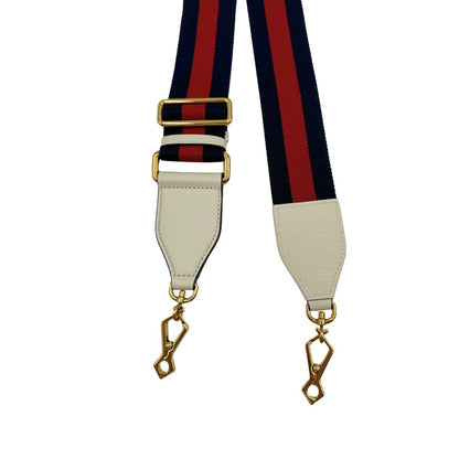 Tracolla Gucci in tessuto con iconica striscia web rossa e blu, rifinita con parti in pelle bianche e parti metalliche dorate.&nbsp;