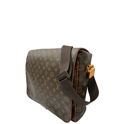 Lato sinistro di una Cartella Louis Vuitton in canvas marrone monogram con finiture in vacchetta naturale e parti metalliche dorate. Munita di una tracolla in tessuto regolabile. Originale, usata, di lusso, in ottime condizioni