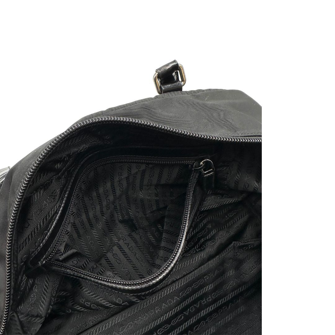 interno Borsa Prada in nylon nero con finiture in pelle tono su tono e parti metalliche argentate; munita di doppi manici e accessorio porta address, di lusso, originale, ottime condizioni, usata. 