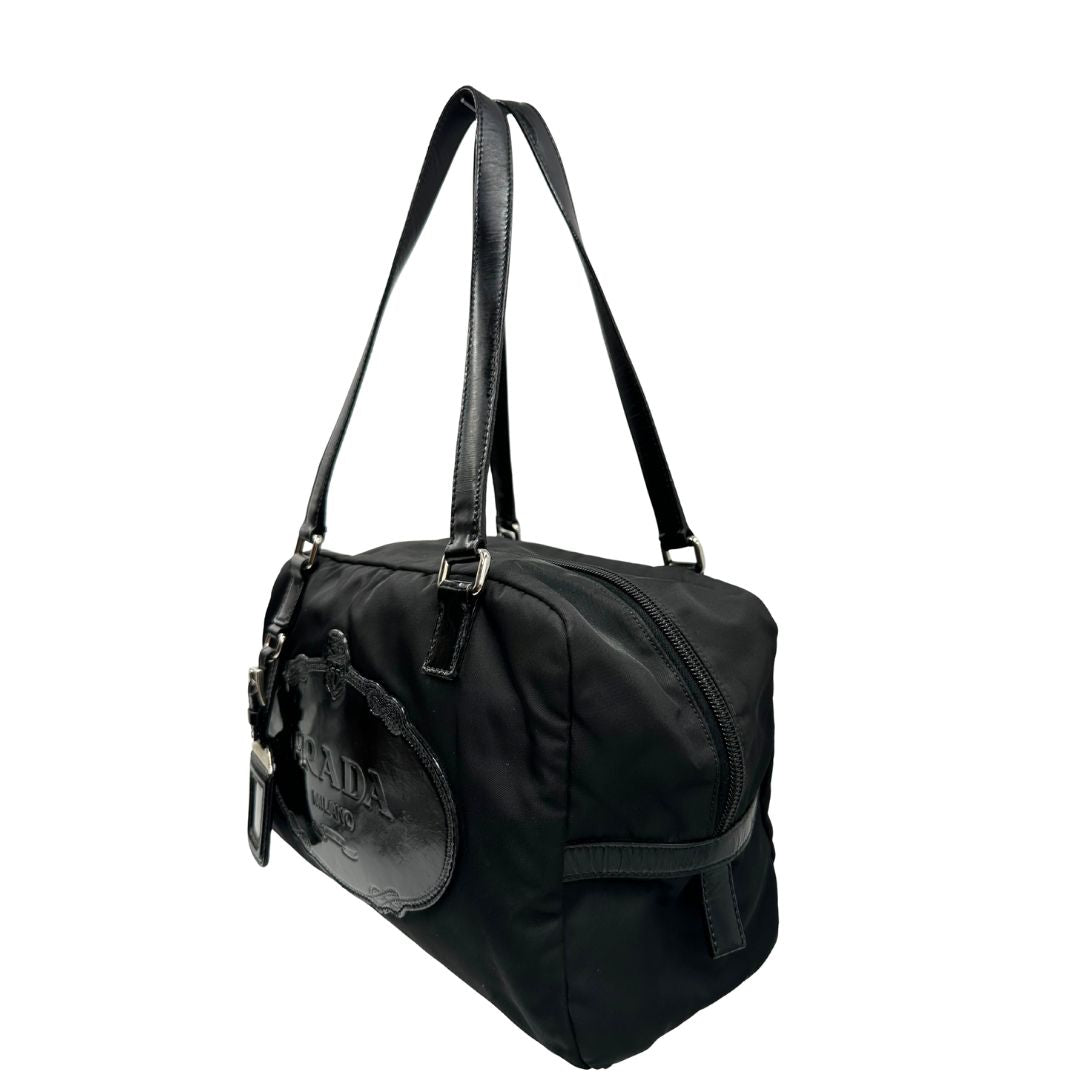 laterale Borsa Prada in nylon nero con finiture in pelle tono su tono e parti metalliche argentate; munita di doppi manici e accessorio porta address, di lusso, originale, ottime condizioni, usata. 