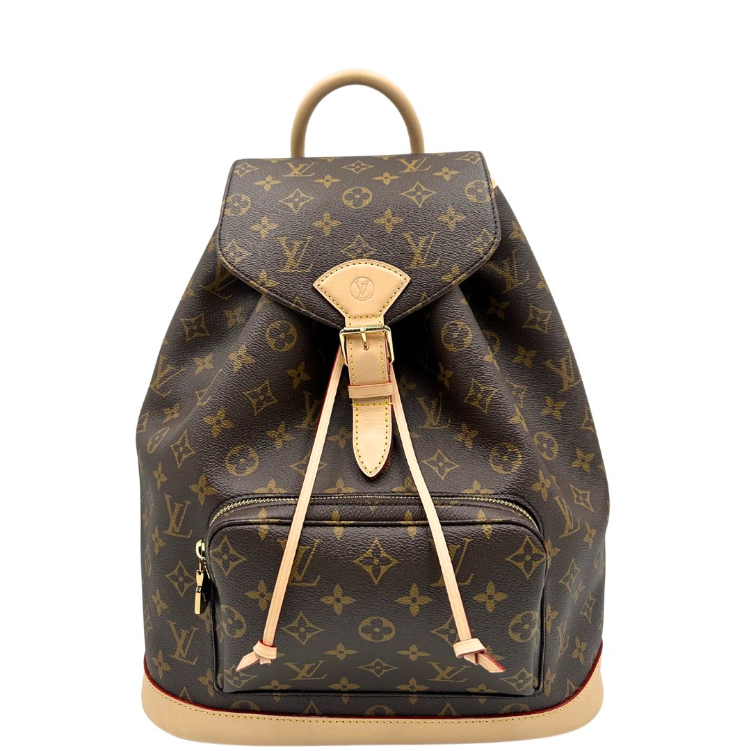 Front di uno zaino LV in canvas marrone monogram con finiture in vacchetta naturale e parti metalliche dorate; munito di due bretelle regolabili. Full set.