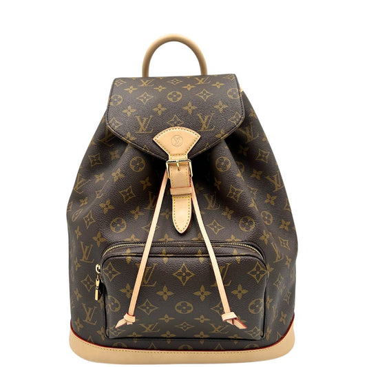 Front di uno zaino LV in canvas marrone monogram con finiture in vacchetta naturale e parti metalliche dorate; munito di due bretelle regolabili. Full set.