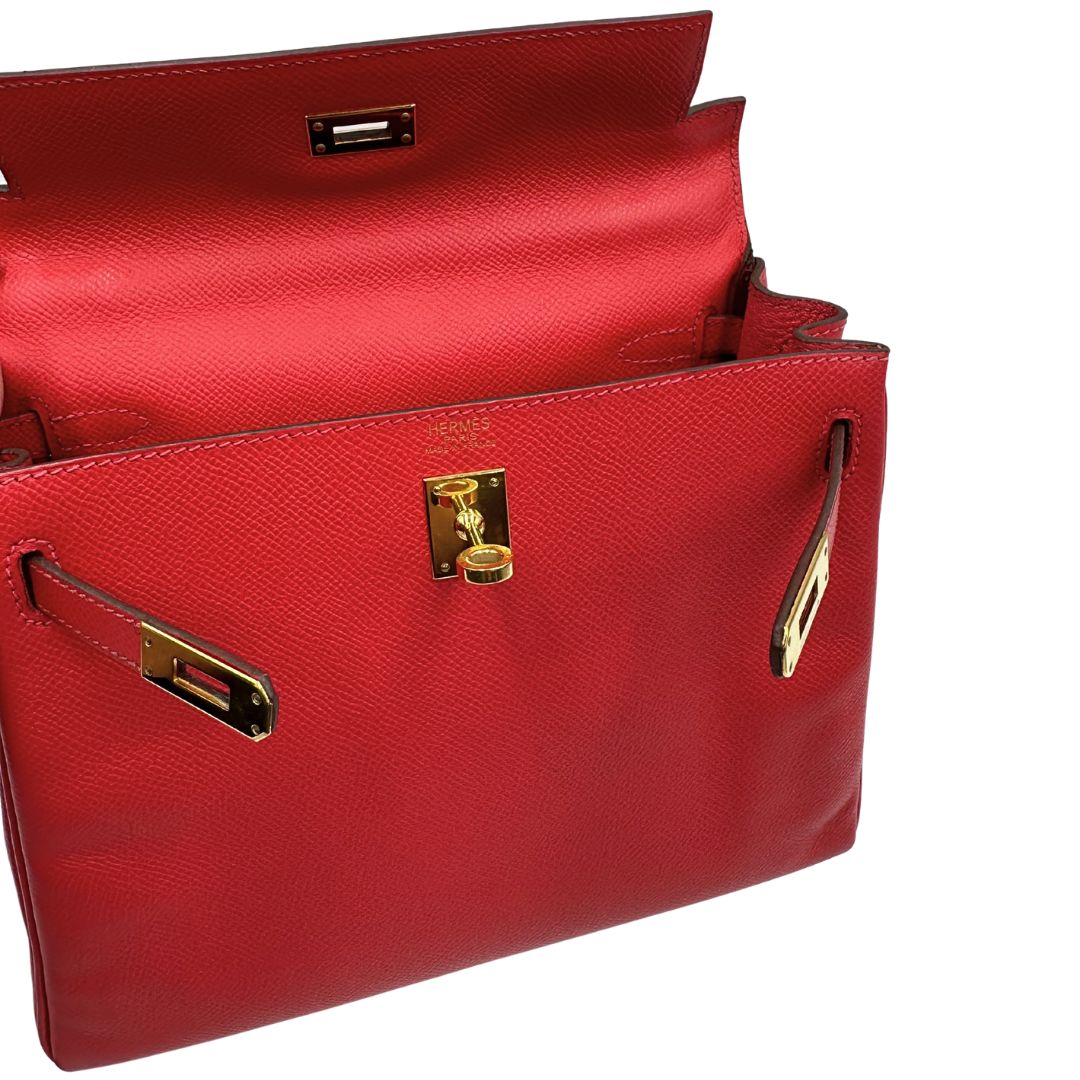 Apertura di una borsa Hermès caratterizzata da un corpo in pelle Epsom color Rouge Casaque, un manico superiore e una tracolla piatta rimovibile e non regolabile; da portare a mano o a tracolla. Completa di full set.