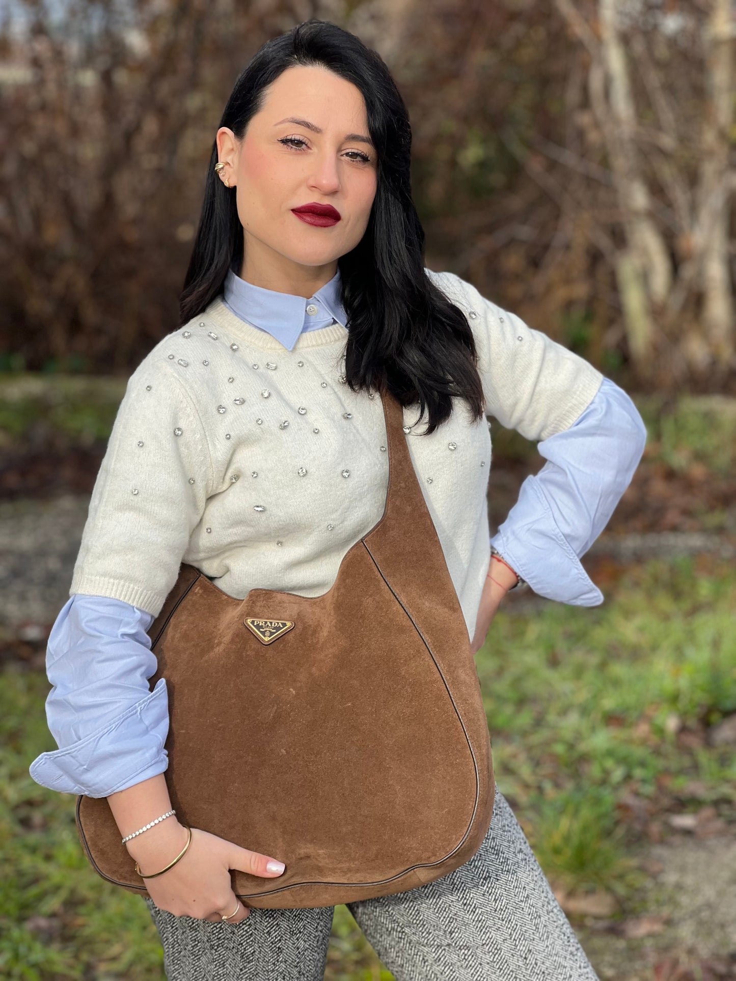 indossata a tracolla Borsa Prada in pelle scamosciata marrone con parti metalliche dorate; munita di un manico singolo regolabile; indossabile a spalla o a tracolla. Completa di dustbag, di lusso, originale, ottime condizioni, usata. 