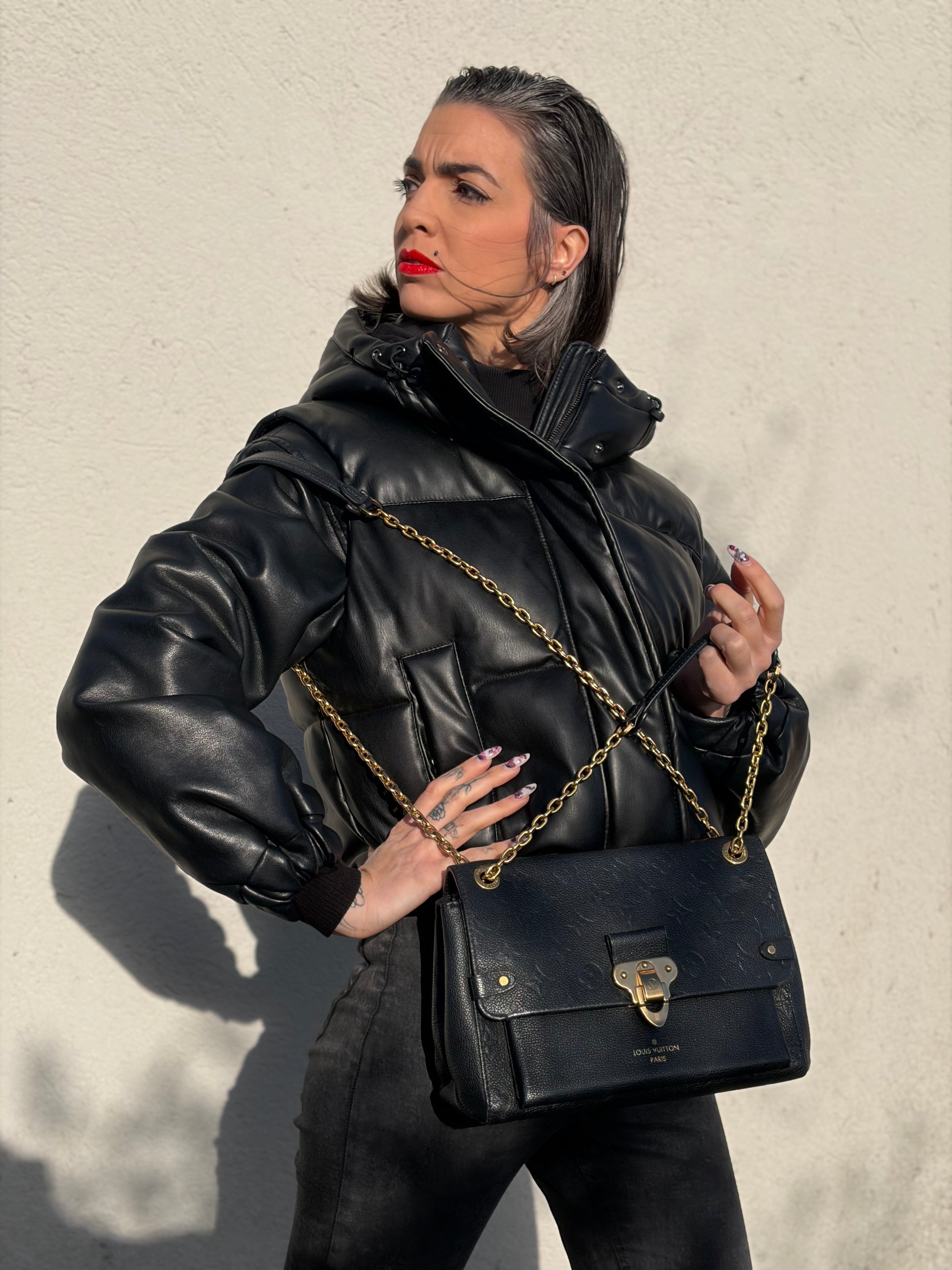 Ragazza che indossa una borsa Louis Vuitton in pelle blu notte Monogram Empreinte, con parti metalliche dorate; munita di una tracolla scorrevole con spallacci in pelle. Completa di scatola.