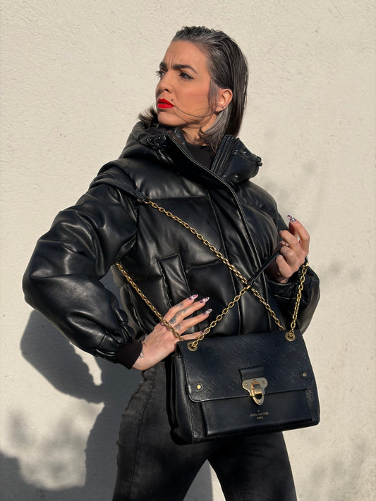 Ragazza che indossa una borsa Louis Vuitton in pelle blu notte Monogram Empreinte, con parti metalliche dorate; munita di una tracolla scorrevole con spallacci in pelle. Completa di scatola.