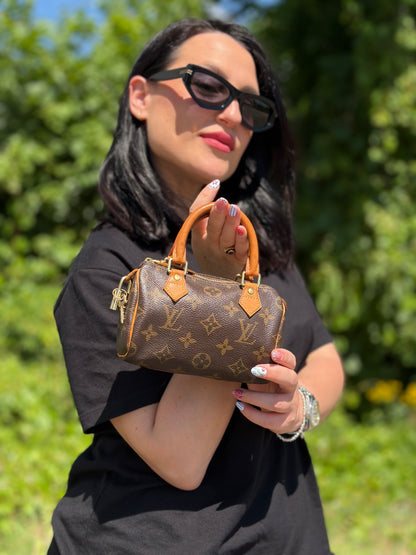Ragazza che indossa uno Speedy Nano Louis Vuitton in canvas marrone monogram, usato, originale, second hand, in ottime condizioni.