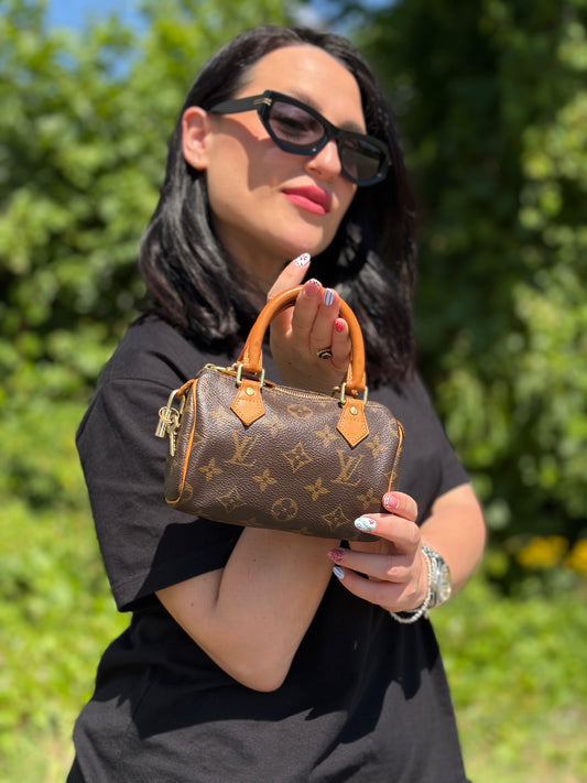 Ragazza che indossa uno Speedy Nano Louis Vuitton in canvas marrone monogram, usato, originale, second hand, in ottime condizioni.
