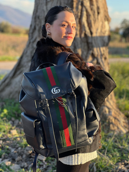 Ragazza che indossa uno zaino Gucci in canvas pelle blu notte, con parti metalliche argentate. Iconica striscia Web in verde/rosso sul front, con cinghie regolabili e tasche laterali. Completo di dustbag.