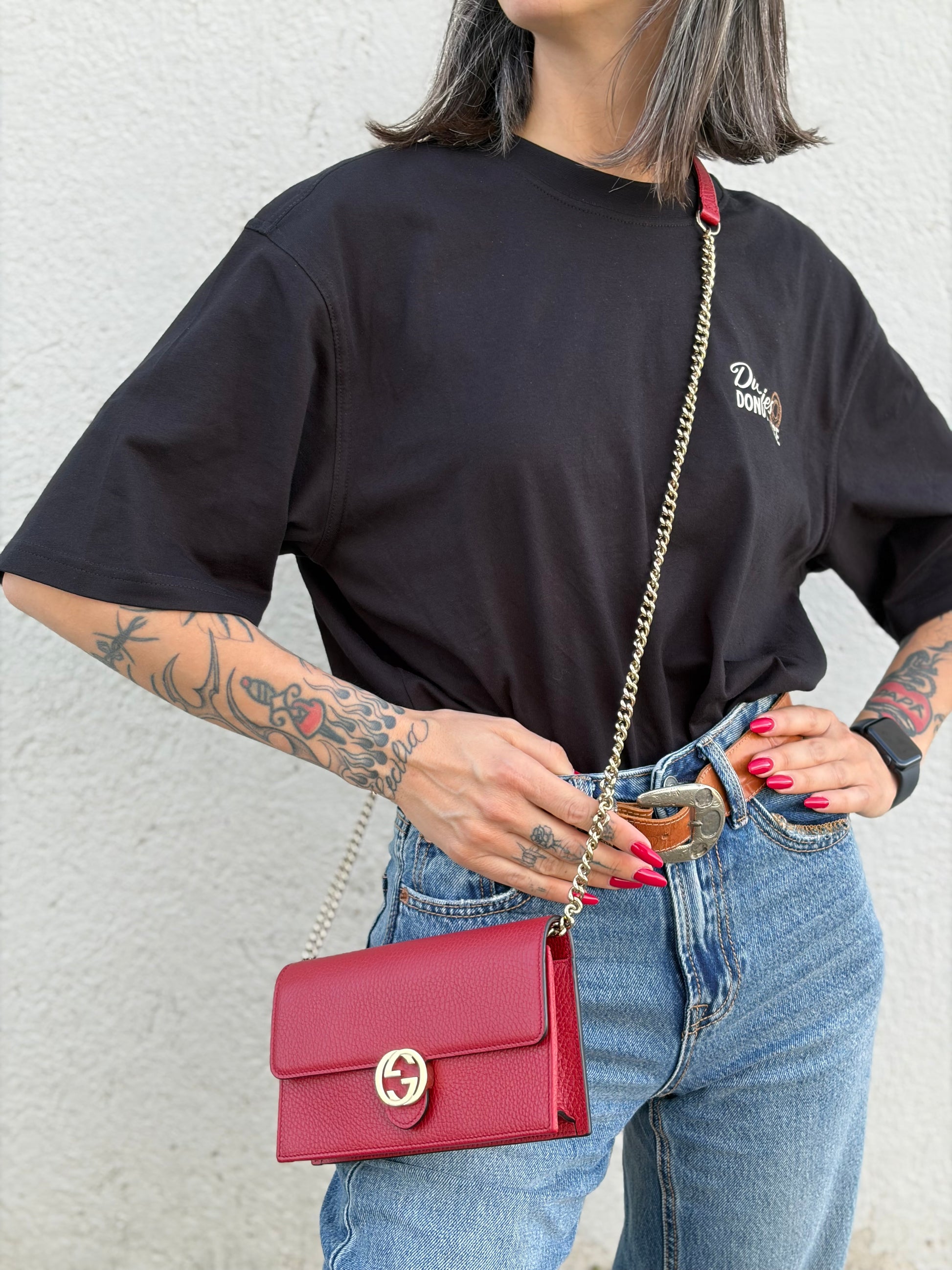 Indossata, Elegante borsa Gucci realizzata in pelle martellata rossa, caratterizzata dall’iconico logo Interlocking dorato. Indossabile a mano oppure a tracolla. Originale, usata, di lusso, in ottime condizioni.
