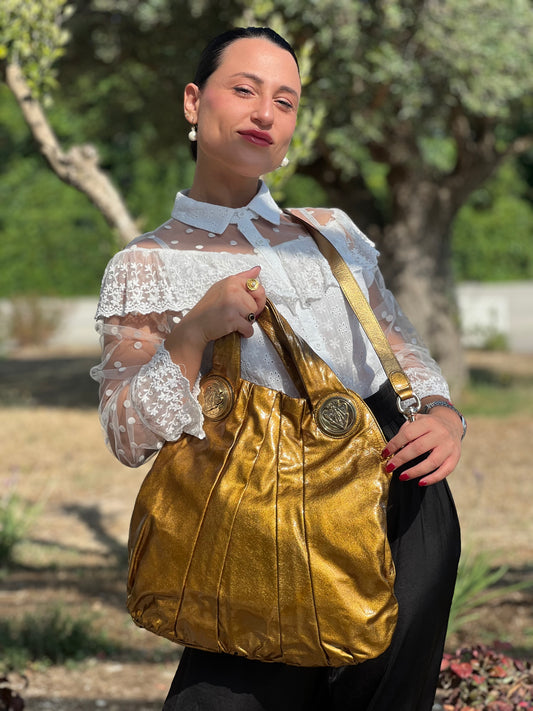 indossata Borsa Gucci in pelle lucida color oro bronzato rifinita con inserti metallici tono su tono; munita di doppi manici e una tracolla amovibile 