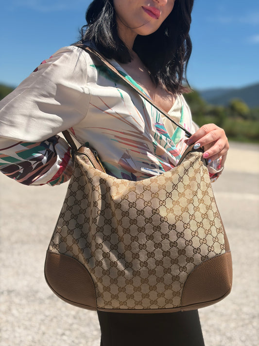 Indossata, Borsa Gucci GG in tessuto e pelle marrone; munita di un manico singolo, indossabile a spalla. Originale, usata, di lusso, in buone condizioni.