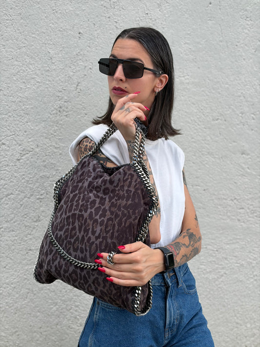 Ragazza che indossa una borsa Stella McCartney modello Fold Over Tote realizzata in shaggy dear greige effetto scamosciato, usata, originale, second hand, in ottime condizioni.