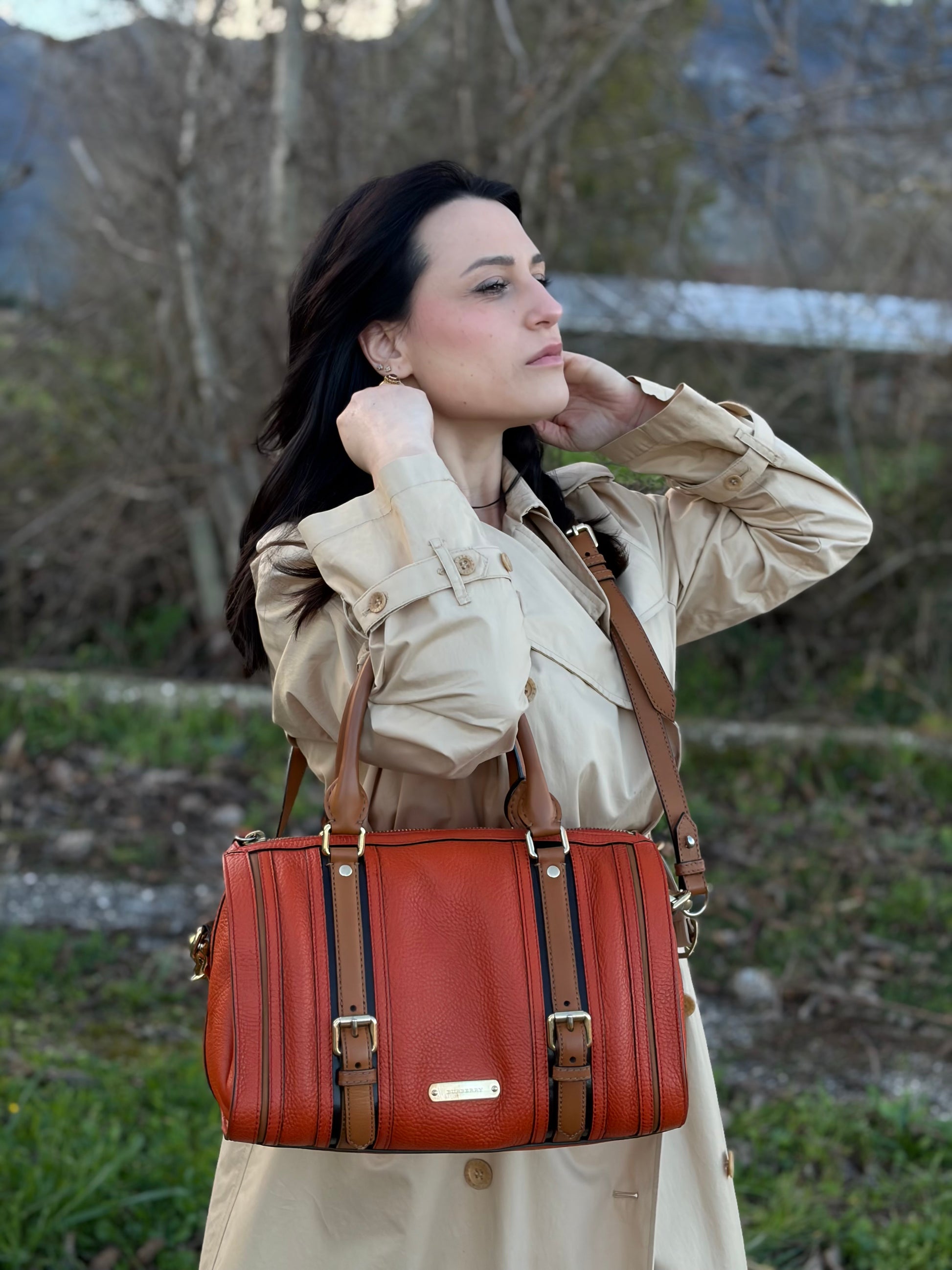 Ragazza che indossa un bauletto Burberry arancione usato, originale, in ottime condizioni, second hand.