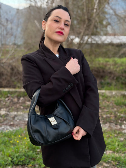Ragazza che indossa una borsa modello hobo Borbonese in morbida pelle nera, con metalleria dorata, usata, originale, second hand, in ottime condizioni.