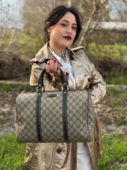 Ragazza che indossa un bauletto Gucci Supreme in canvas beige e dettagli in pelle marroni.